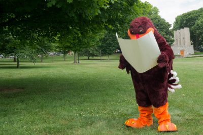 Hokie Bird looking at a map on the Drill Field.